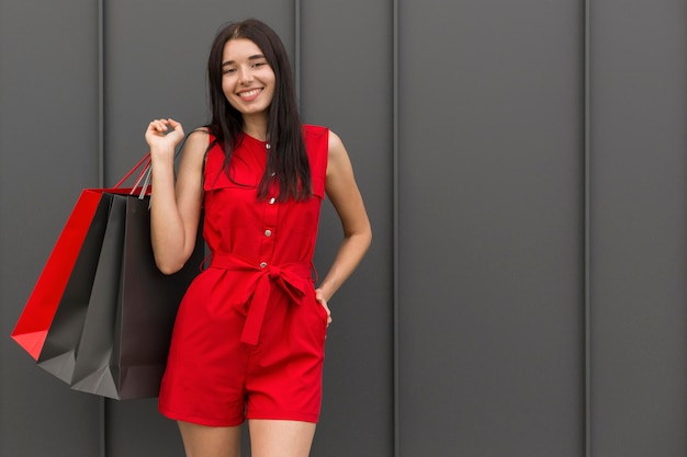 Mujer vestida con ropa roja y sosteniendo bolsas