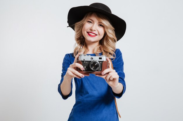 Mujer vestida de vestido azul con sombrero con cámara