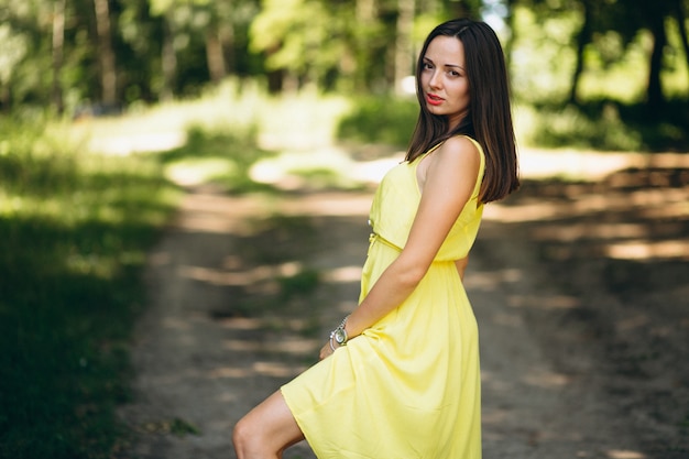 Mujer en vestido amarillo en el parque