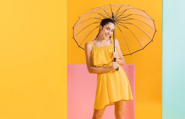 Mujer en vestido amarillo con sombrilla