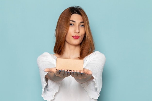 mujer en vestido blanco con caja presente