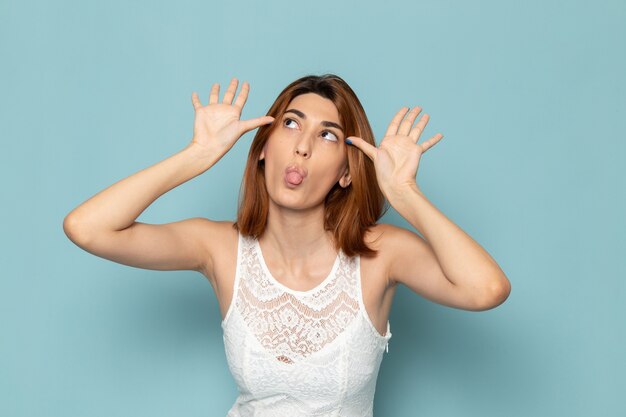 mujer en vestido blanco mostrando caras divertidas