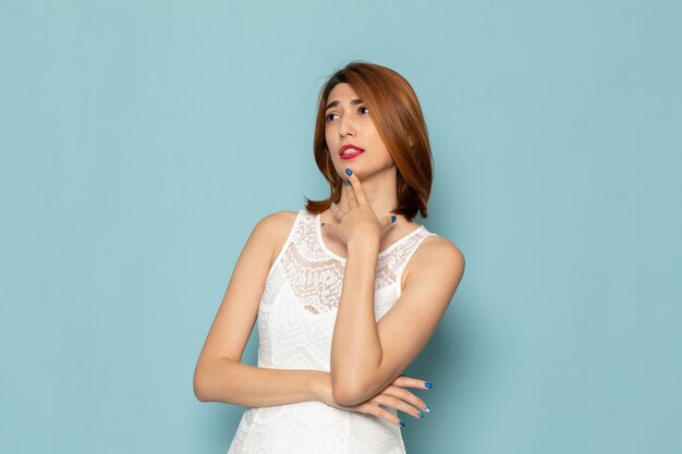 mujer en vestido blanco posando con expresión de pensamiento