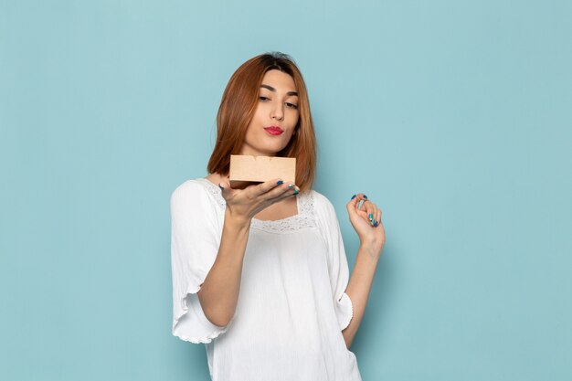 mujer en vestido blanco sosteniendo cajita