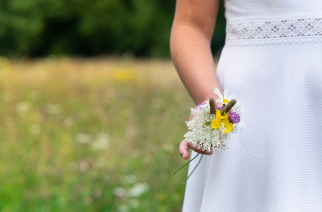 Mujer con un vestido blanco y sosteniendo hermosas flores de colores