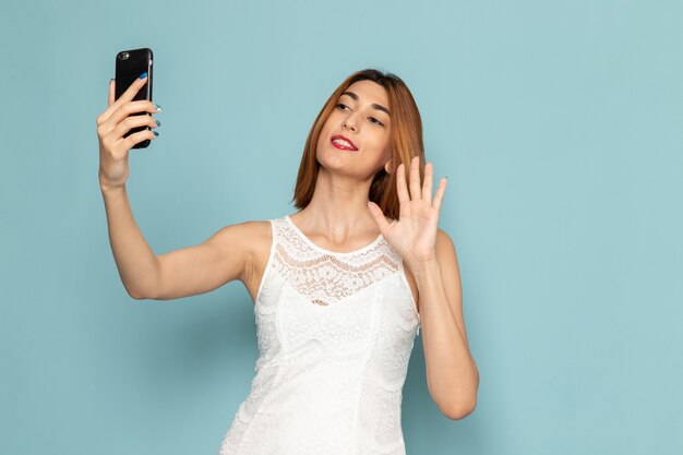 mujer en vestido blanco sosteniendo teléfono mujer