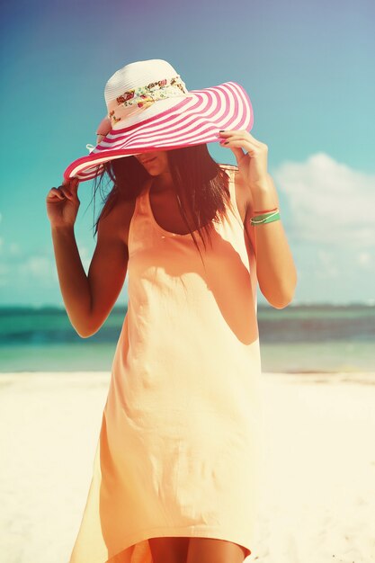 mujer en vestido colorido caminando en la playa