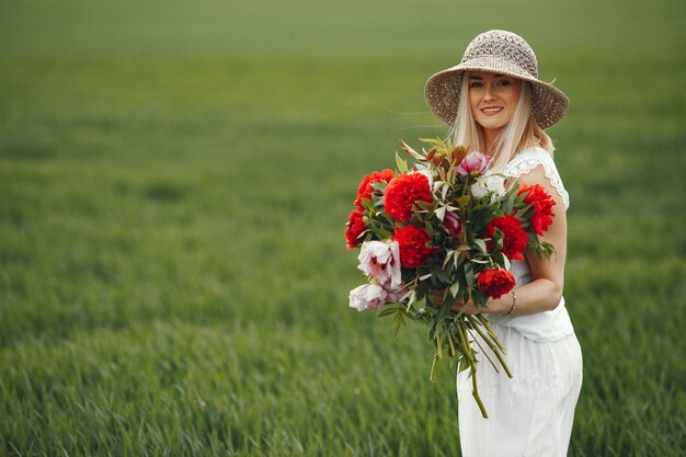 Mujer en vestido elegante de pie en un campo de verano