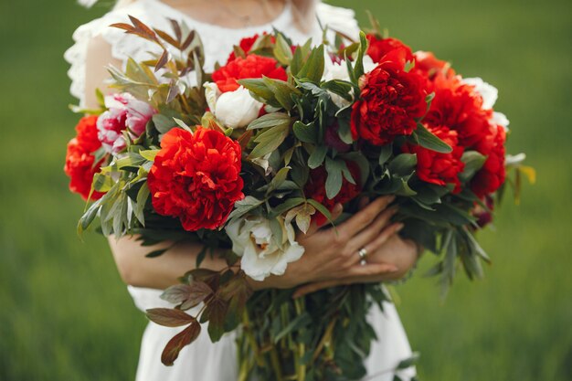 Mujer en vestido elegante de pie en un campo de verano