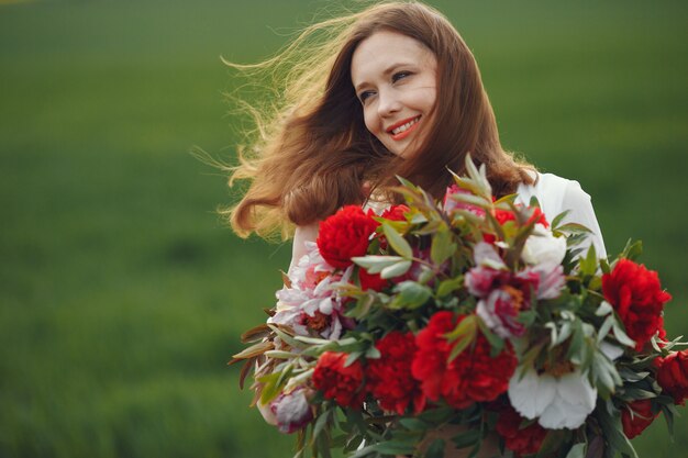 Mujer en vestido elegante de pie en un campo de verano