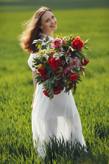 Mujer en vestido elegante de pie en un campo de verano