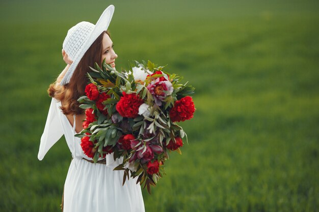 Mujer en vestido elegante de pie en un campo de verano