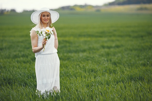 Mujer en vestido elegante de pie en un campo de verano