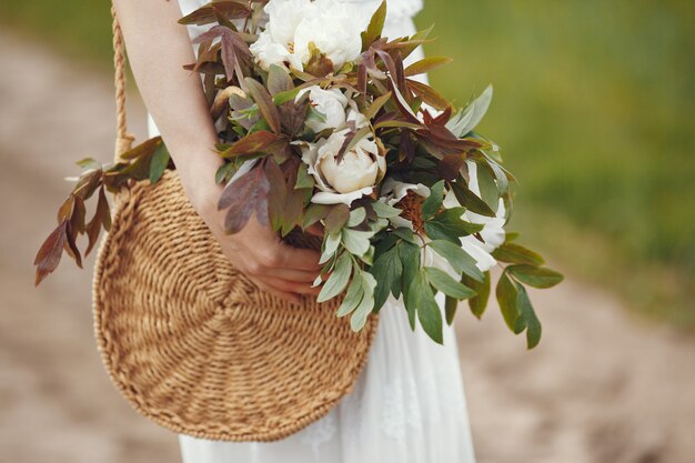 Mujer en vestido elegante de pie en un campo de verano