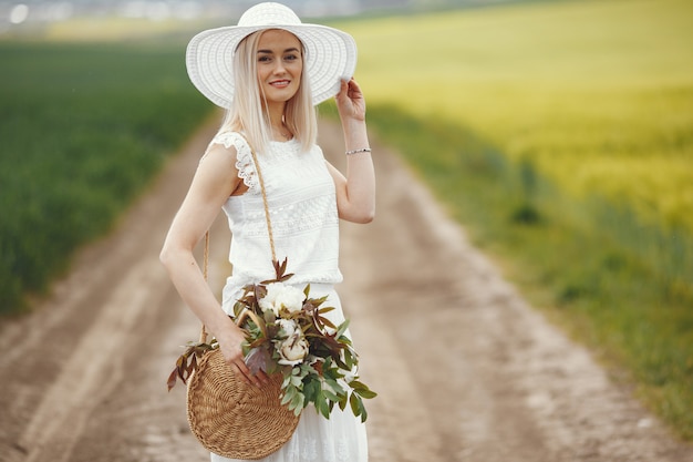 Mujer en vestido elegante de pie en un campo de verano