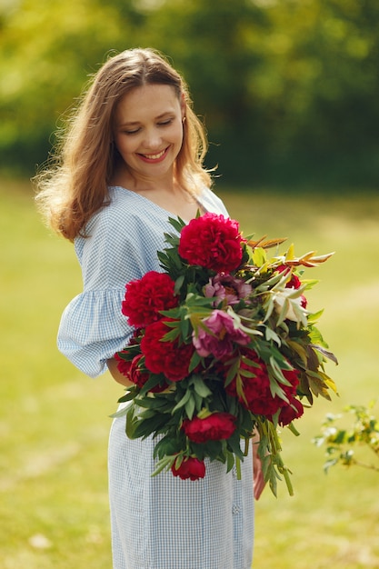 Mujer en vestido elegante de pie en un campo de verano