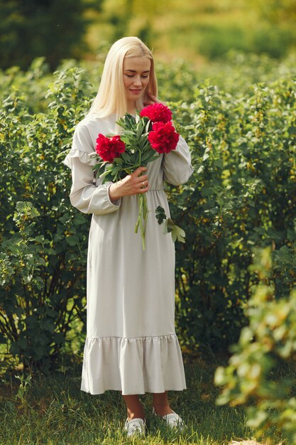 Mujer en vestido elegante de pie en un campo de verano