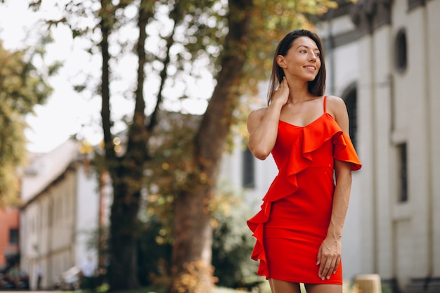 Mujer en vestido rojo afuera en la ciudad