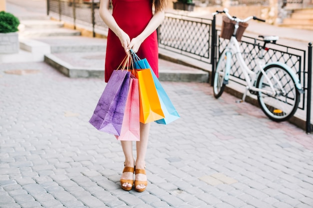 Foto gratuita mujer en vestido rojo con bolsas de papel