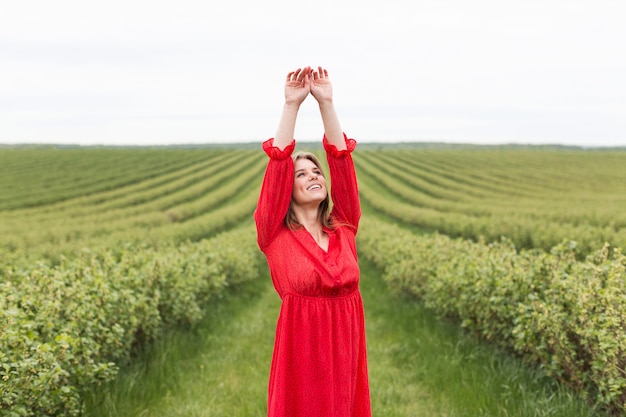 Mujer con vestido rojo en campo