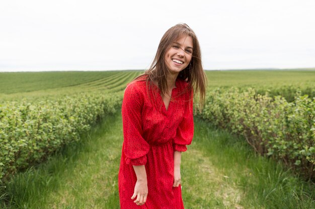Mujer con vestido rojo en campo