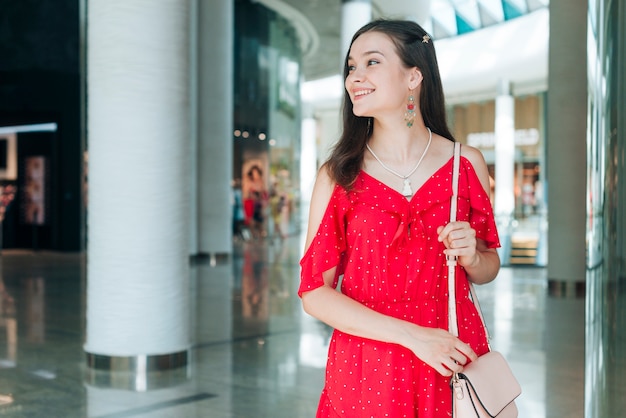 Mujer con vestido rojo mirando a otro lado