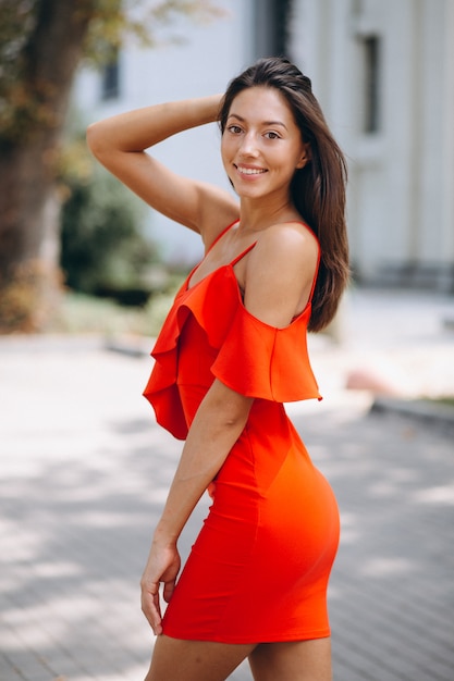 Mujer en vestido rojo modelo posando afuera