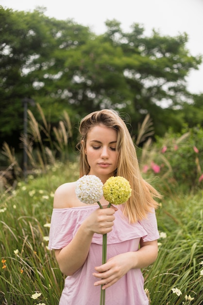 Mujer en vestido sosteniendo flores en la mano