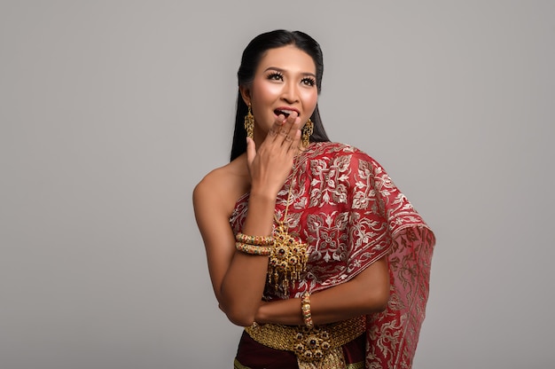 Foto gratuita mujer con vestido tailandés que hizo un símbolo de mano