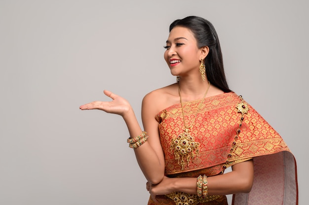Mujer con vestido tailandés que hizo un símbolo de mano