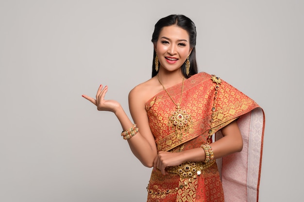 Mujer con vestido tailandés que hizo un símbolo de mano
