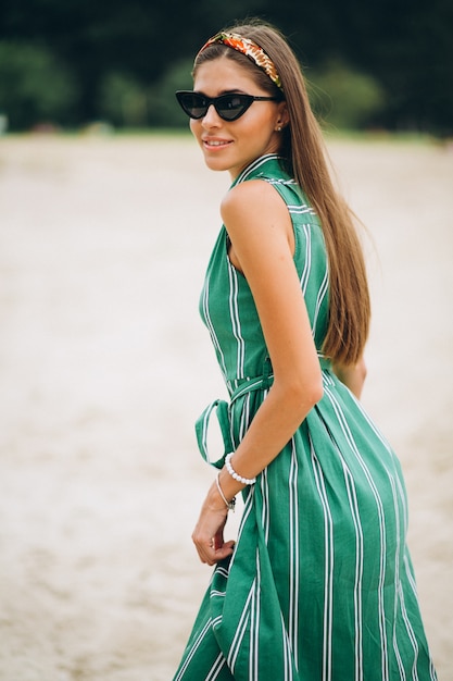 Mujer en vestido verde en la playa