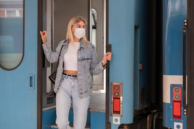 Mujer viajando en tren con máscara médica para protección