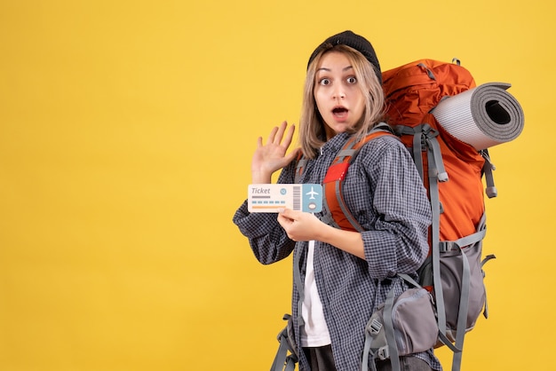 Mujer viajera aturdida con mochila con boleto