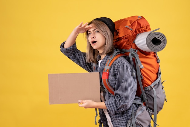 mujer viajera con mochila roja con cartón