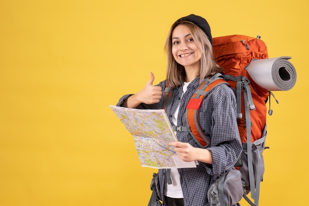 mujer viajera, con, mochila, tenencia, mapa, hacer, pulgar arriba, señal