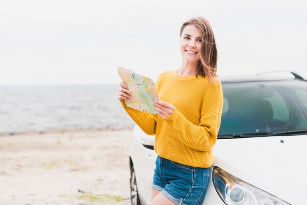 Mujer viajera sosteniendo un mapa frente a la cámara