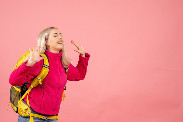 Mujer de viajero de vista frontal con mochila expresando su felicidad