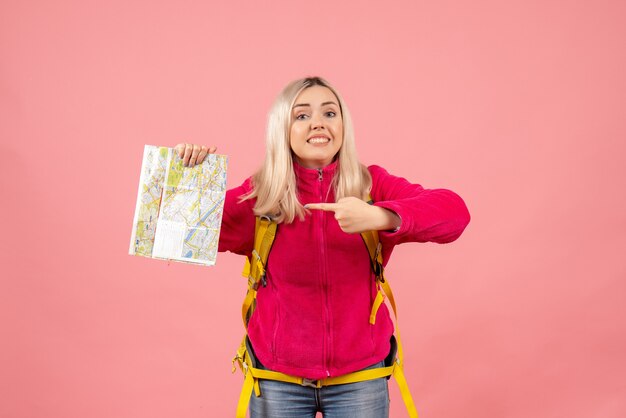 Mujer de viajero de vista frontal en ropa casual con mochila apuntando al mapa