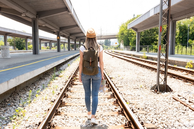 Mujer en vías del ferrocarril desde atrás