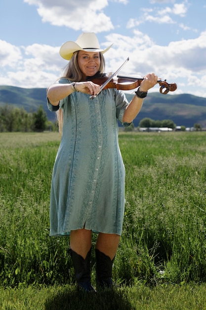 Mujer con violine preparándose para un concierto de música country