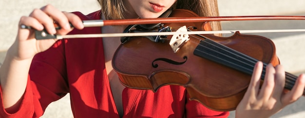 Mujer violinista tocando con instrumento y arco