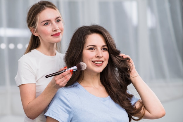 Mujer visagiste haciendo maquillaje