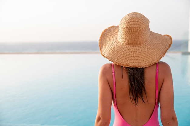 Mujer de visión trasera, posición, en la piscina