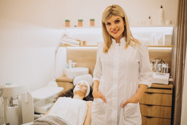 Mujer visitando cosmetóloga y realizando procedimientos de rejuvenecimiento.