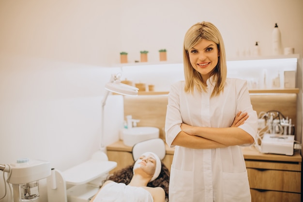 Mujer visitando cosmetóloga y realizando procedimientos de rejuvenecimiento.