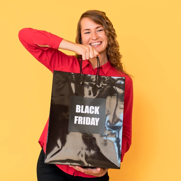 Mujer de vista frontal con bolsa de compras de viernes negro