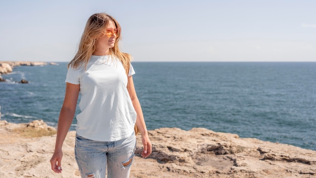 Mujer de vista frontal dando un paseo por la playa con espacio de copia