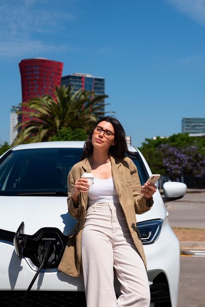 Mujer de vista frontal esperando que se cargue el auto