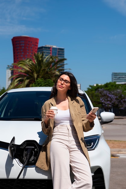 Mujer de vista frontal esperando que se cargue el auto